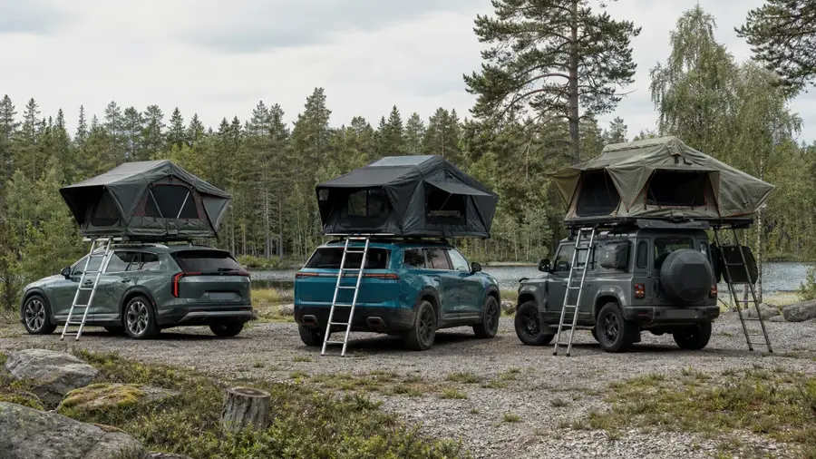 Tre olika taktält monterade på bilar vid en testplats