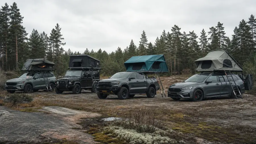 Flera modeller av taktält på bilar i en skogsglänta
